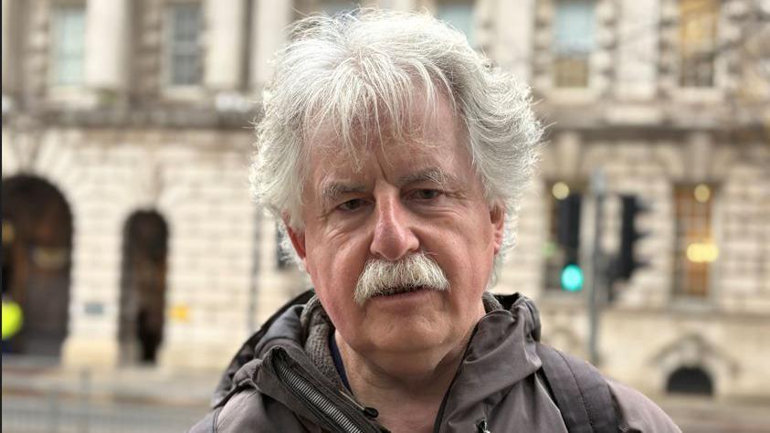 Philip Stevenson, a man with grey hair and grey moustache and dark grey jacket.