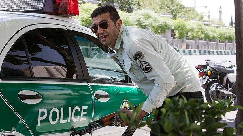 An Iranian policeman takes cover during an attack on the Iranian parliament in central Tehran, Iran (7 June 2017)