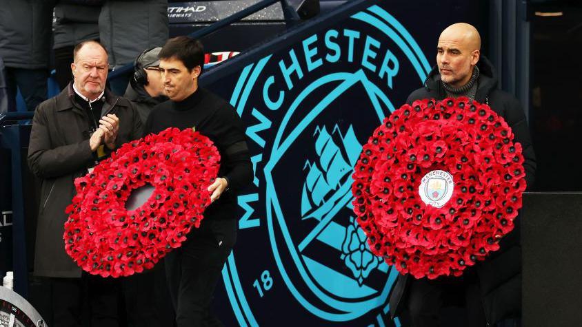 Andoni Iraola, manager of AFC Bournemouth, and Pep Guardiola, Manager of Manchester City, hold poppy wreaths on November 04, 2023 in Manchester, England