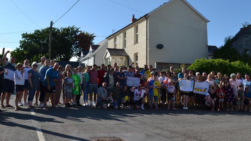 A crowd of wellwishers greet Bleddyn on his return home