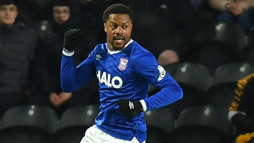 Chuba Akpom jumps off the ground in celebration after scoring his first goal for Ipswich Town