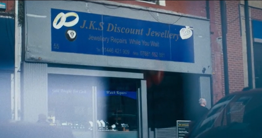 Outside of a jewellery store in Barry. The sign is blue with silver jewels and reads: J.K.S Discount Jewellery. Jewellery repairs while you wait. 