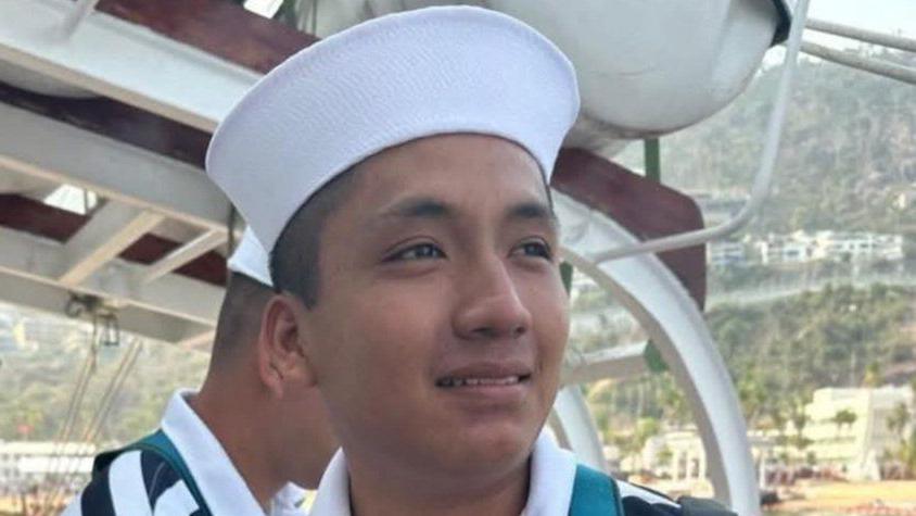 An undated photo shows a smiling Adal Jair Maldonado Marcos in a stripy top and a cao aboard a ship.