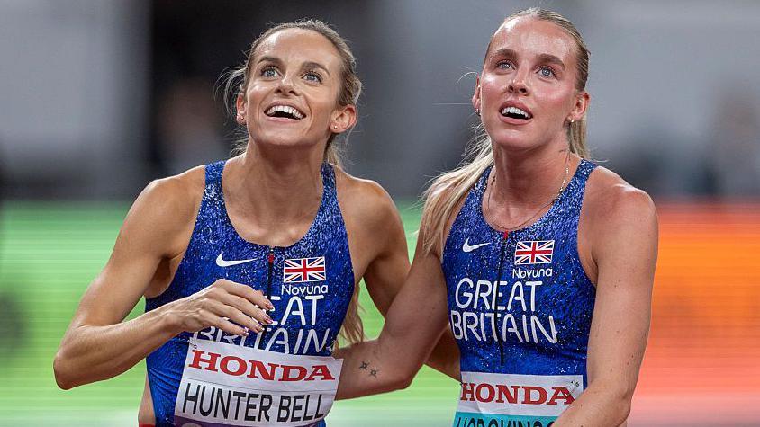 Georgia Hunter Bell and Keely Hodgkinson look up at the big screen for the results following the World Championships 800m final in Tokyo