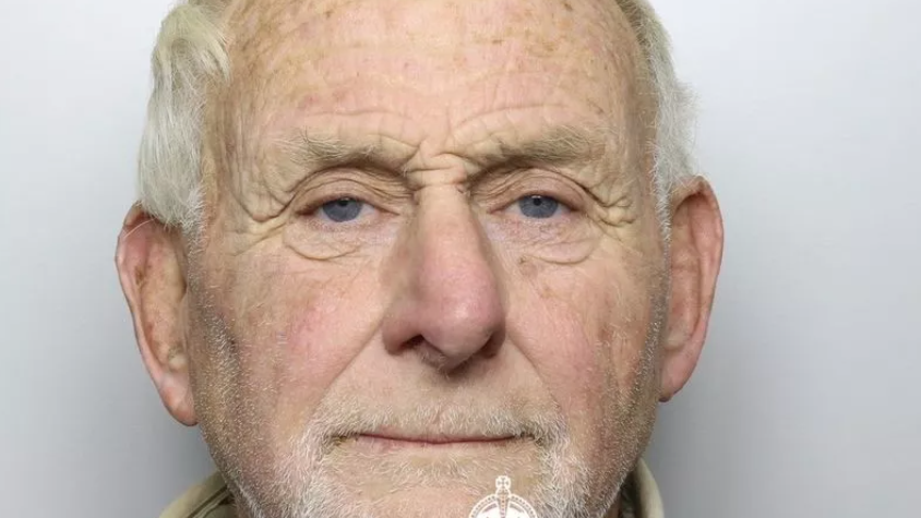 A close-up police shot of 72-year-old Flavin looking straight into camera with white, receding hair and untidy white stubble