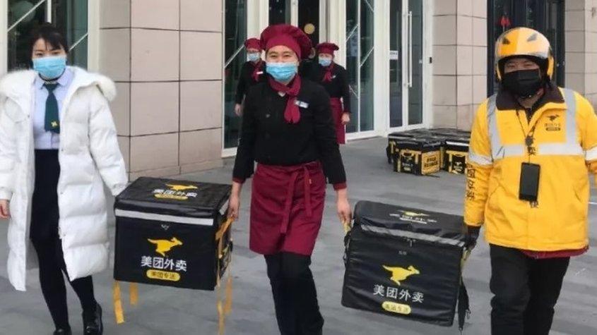 Hospital staff carrying food