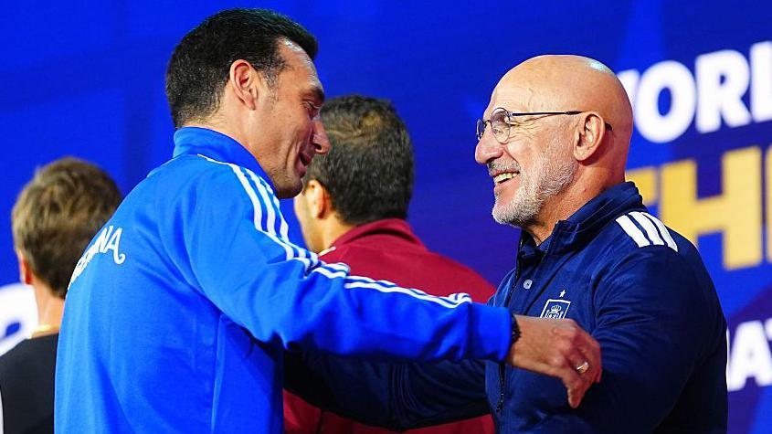 Lionel Scaloni and Luis de la Fuente hug on stage at Fanatics Fest before the 2026 World Cup final