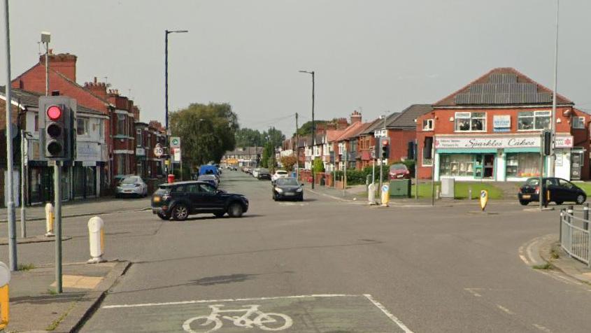 Shops and traffic lights at crossroads junction of Moston Lane East