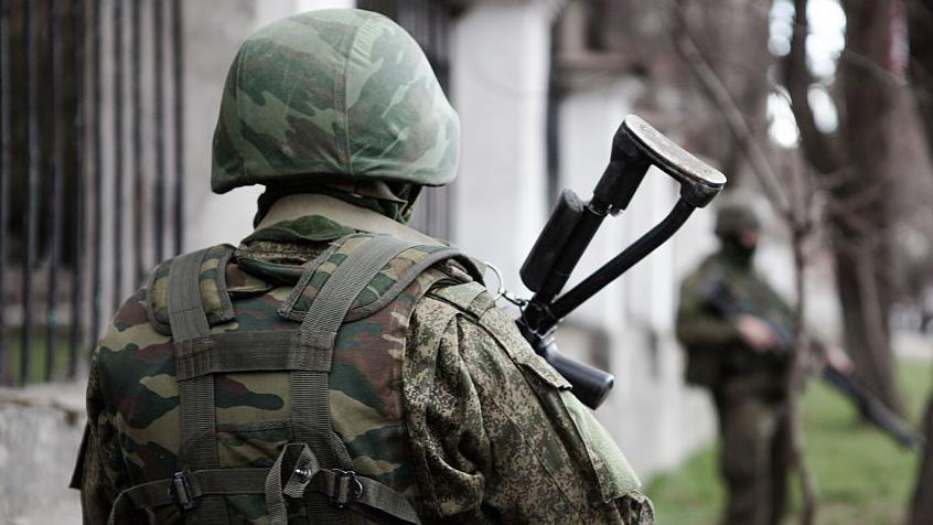 An unidentifiable Russian soldier stands with his back to the camera