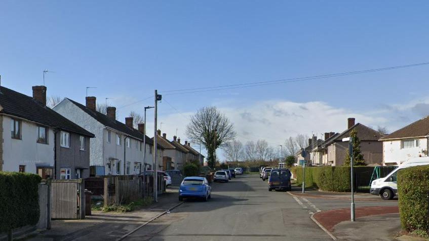 A Google streetview picture of houses on Regina Crescent in Havercroft. There are semi-detached houses on either side of the street and several parked cars. 