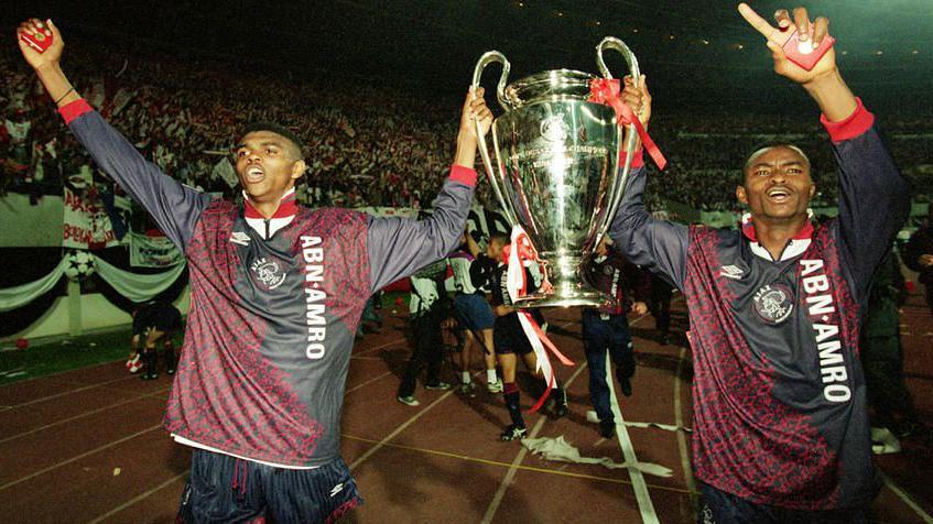 Ajax players Nwankwo Kanu and Finidi George hold the Uefa Champions League trophy