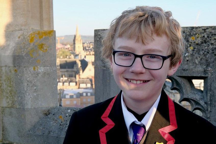 A younger Alastair in his school uniform on top of Magdalen Tower.