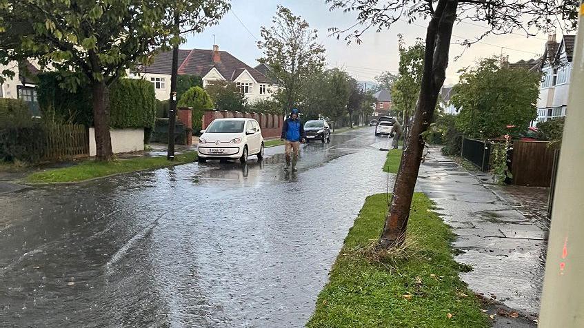 A residential street in Cheltenham beginning to flood as heavy rain falls