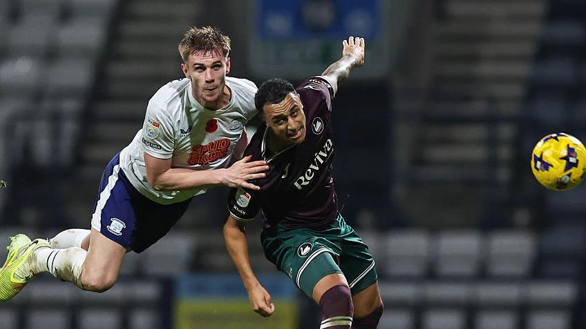 Preston North End's Liam Lindsay heads the ball under pressure from Swansea City's Adam Idah