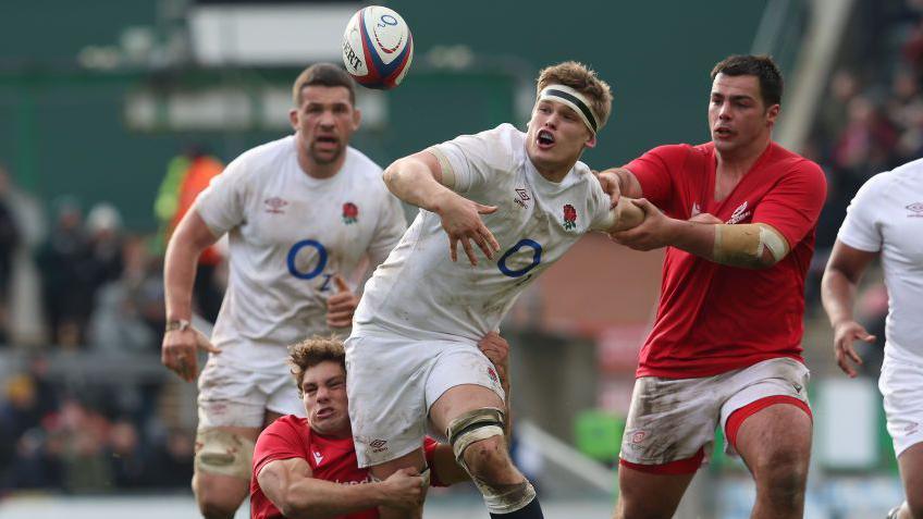 Guy Pepper chases a ball under pressure from Portugal defenders