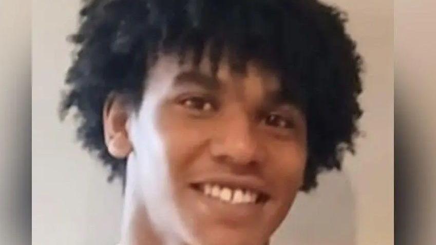 A man with dark hair smiles at the camera.