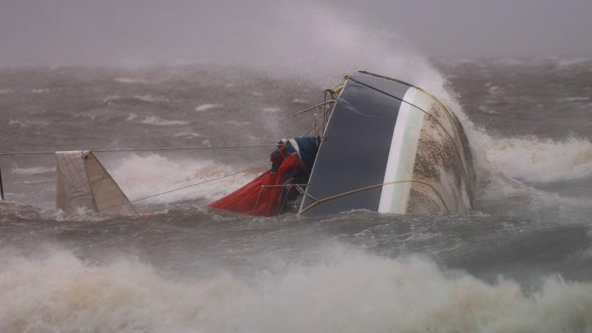 A capsized boat washes ashore in Saint Petersburg, Florida
