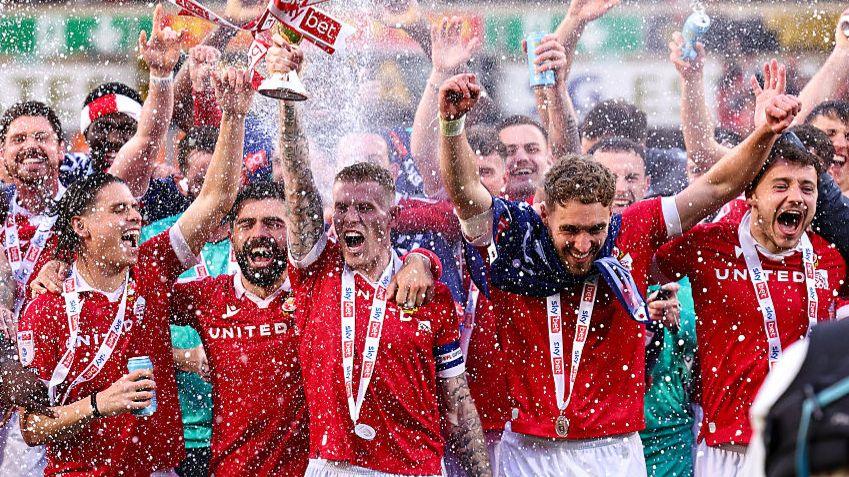 Wrexham players celebrate promotion into the Championship