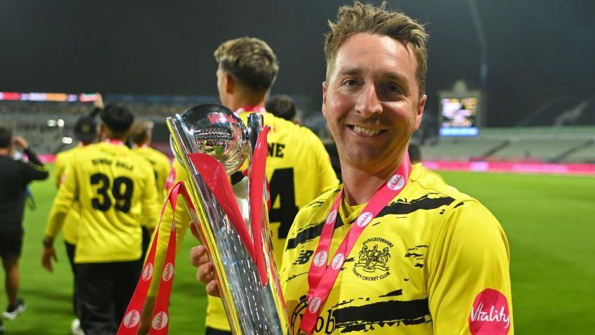 Gloucestershire spinner Tom Smith holds the T20 Blast trophy after his side's win in 2024