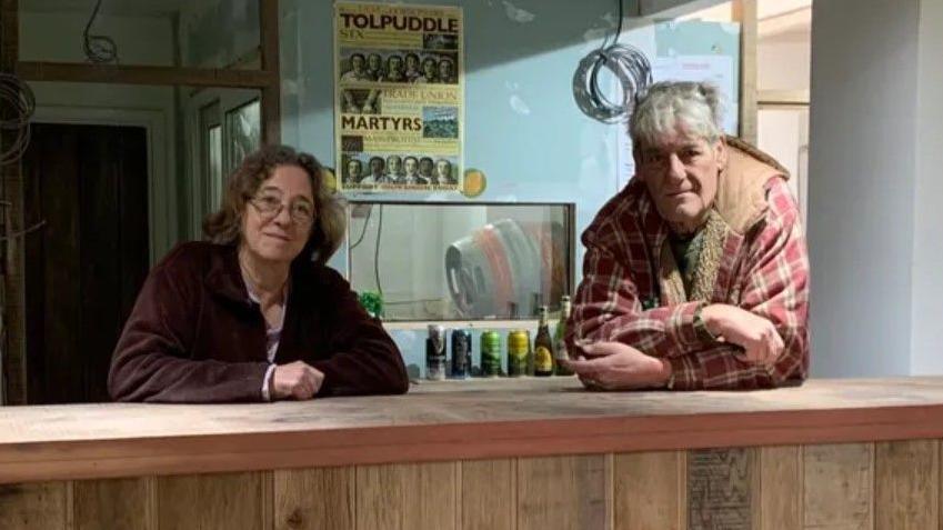 Tessa and Julian Blundy posing behind the newly built bar at the Bottle Inn. Work inside the pub is still ongoing - there are no pumps, the walls have not been painted and cables can be seen hanging from the ceiling.