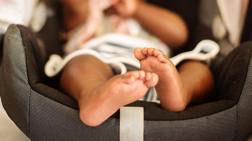 Newborn baby in travel seat