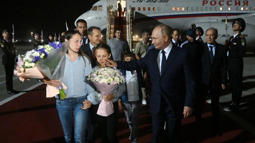  In this pool photograph distributed by Russian state agency Sputnik, Russia's President Vladimir Putin welcomes Russian citizens released in a major prisoner swap with the West, at Moscow's Vnukovo airport on August 1, 2024. 