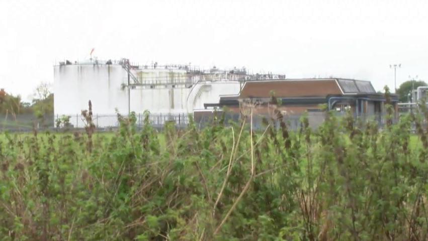 Dalston Terminal, in Cumbria. It consists of a brown stone building and a number of large white tanks.