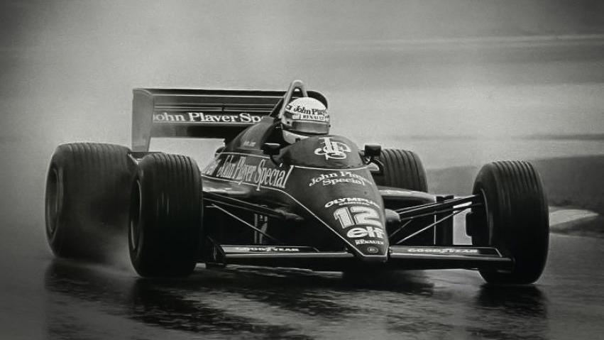 A black and white photo of a racing driver in a F1 car on a track