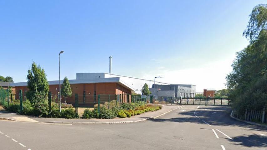 The completed plant with its large chimney rising into a blue sky