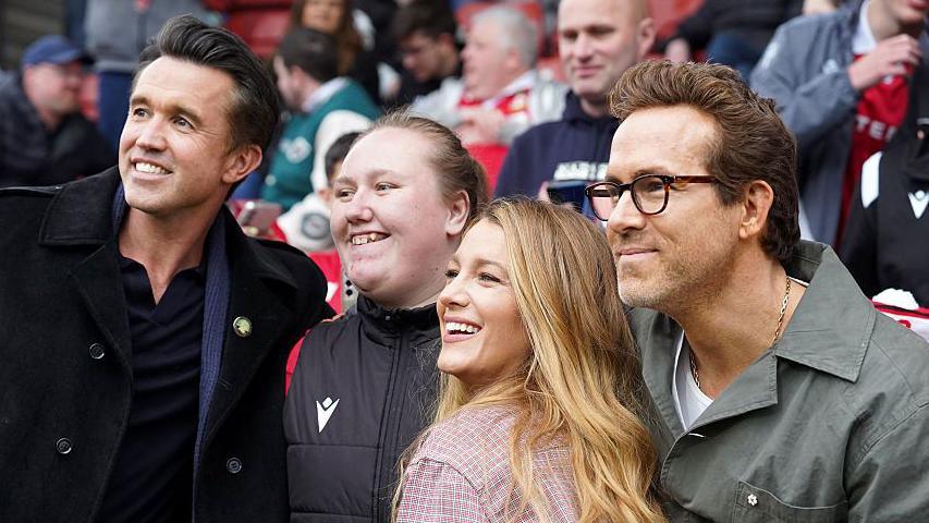 Ryan Reynolds and Rob McElhenney and Blake Lively pose with a fan