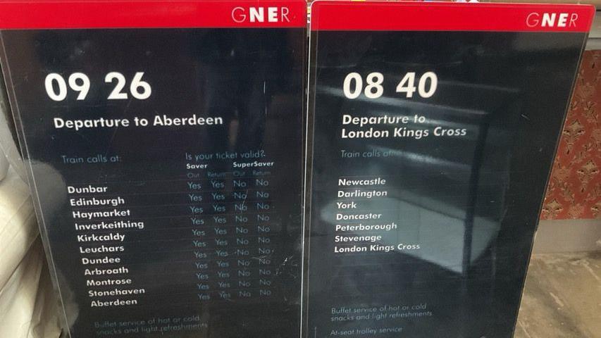 An old railway sign showing the departure times and stopping points of a train service