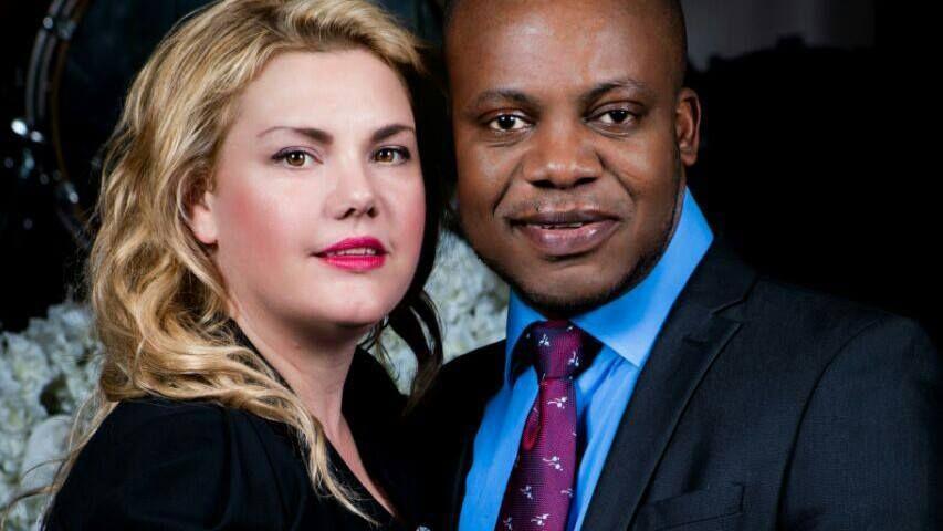 Close-up portrait of a man and woman standing together, both dressed in formal clothing and facing the camera.