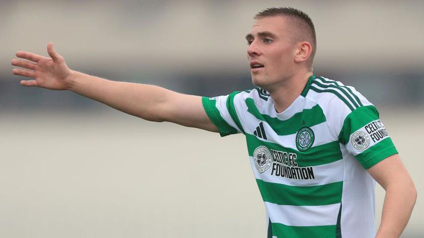 Kyle Ure puts is arm out offering some instructions to team-mates during a game for Celtic