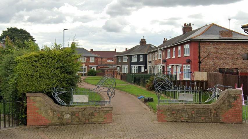 General view of a paved pathway between houses