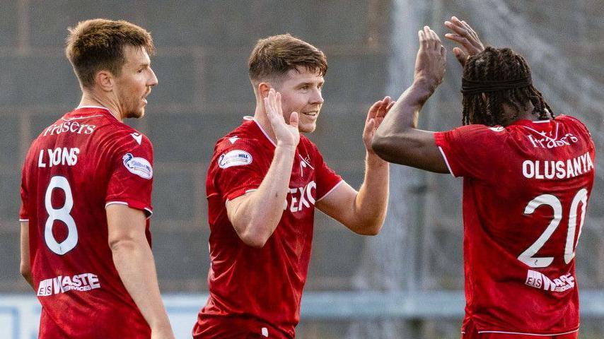 Kevin Nisbet (centre) celebrates with Brad Lyons (left) and Toyosi Olusanya
