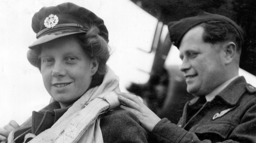 Leading Aircraftwoman Edna Birbeck has her parachute checked by Warrant Officer FB Knight from Melbourne, Australia, 13 June 1944