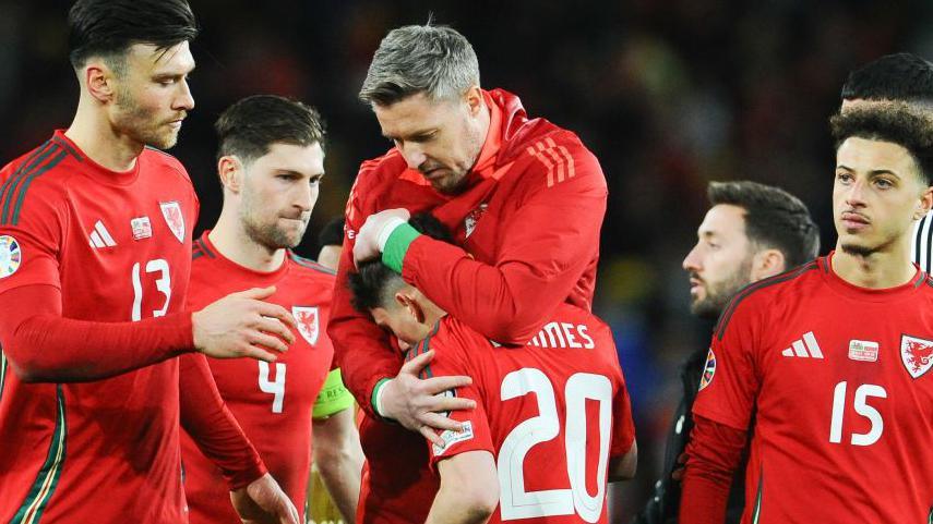 Wales' Daniel James is consoled by his team mates after missing a penalty during the UEFA EURO 2024 Play-Offs Final match between Wales and Poland at Cardiff City Stadium on March 26, 2024