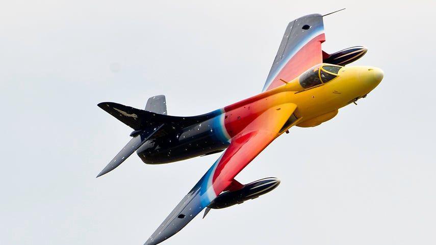A multicoloured plan soars through the sky during a previous Lowestoft air show on a cloudy day.