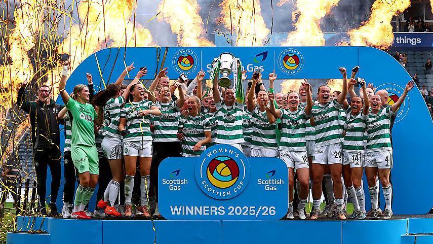 Kelly Clark lifting the Women's Scottish Cup trophy.
