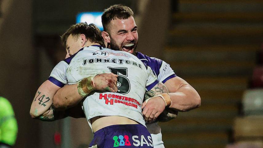 Try scorer Tom Johnstone is lifted off the turf in celebration by Wakefield captain Mike McMeeken