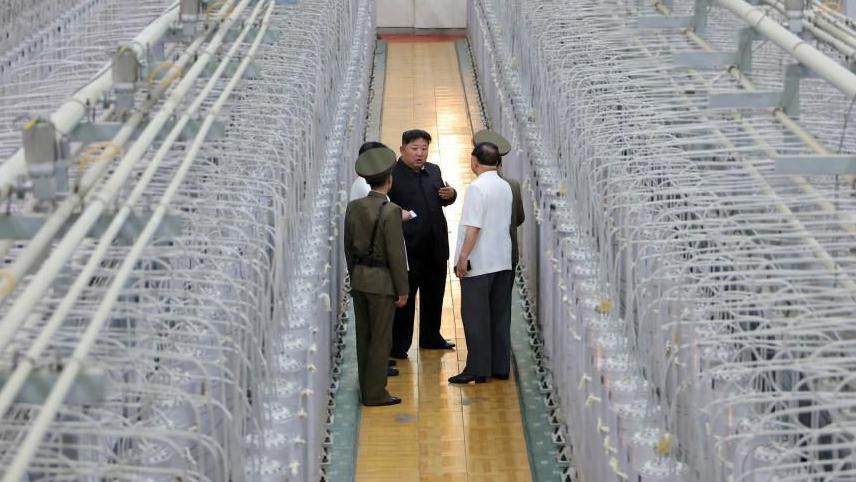 Kim walks past rows of centrifuges and talks to military officials at the Nuclear Weapons Institute