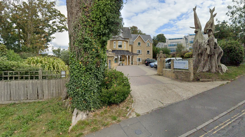 A Google Maps picture of The Moorings, a three-storey house with two very large trees, which appear to have been large cut down, outside it beside its driveway.