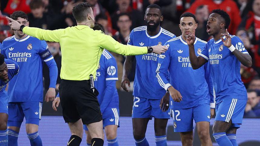 French referee Francois Letexier talks to Vinicius Jr and Real Madrid players after an allegation of racist abuse by Benfica's Gianluca Prestianni