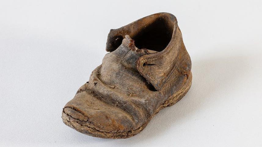 A very old child's shoe, cracked leather with dirt