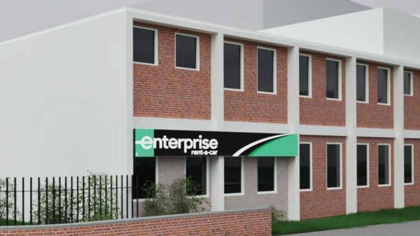 An architect's rendering of a proposed car rental use for the former Sentinel Works. The building is white with red bricks, and there is a black and green sign on the front that reads "enterprise rent-a-car"