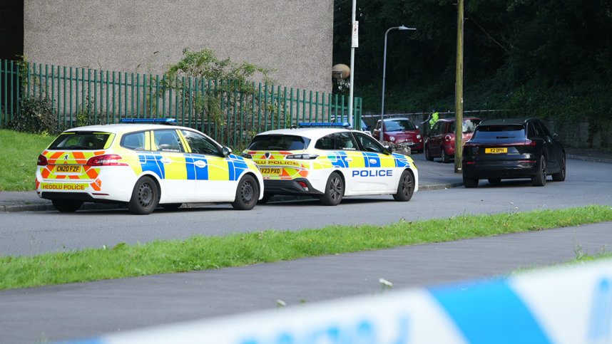 The police cordon and cars parked on Cwm Road