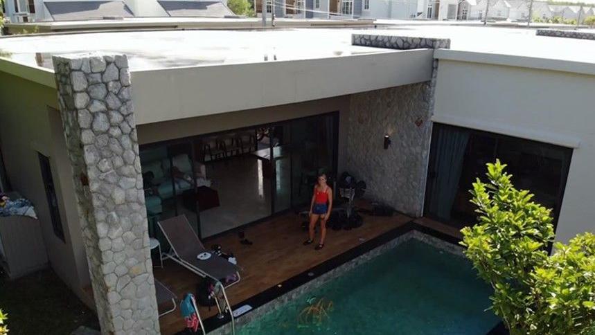 A woman standing on the deck of a Thai villa