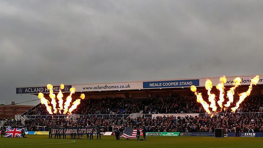 Pyrotechnic displays as well as United Kingdom and United States flags greeting new Hartlepool owner Landon Smith's arrival before their home fixture against Altrincham.