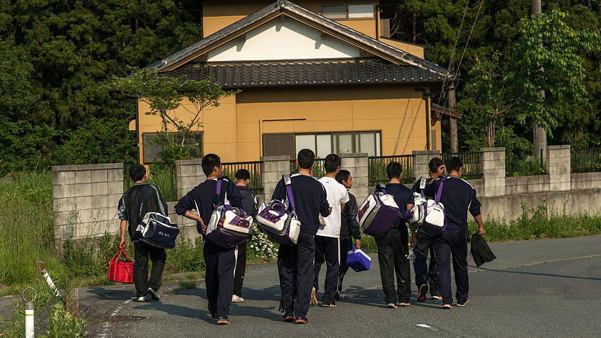 A group of Japanese teenage boys walking on the street