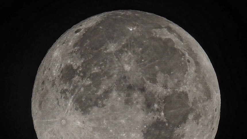 A detailed grey moon against a black background